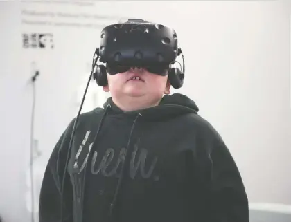  ?? PHOTOS: BRANDON HARDER ?? Exton Mcintyre tries out one of the virtual reality stations at the Regina Public Library’s Central branch.