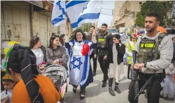  ?? (Erik Marmor/Flash90) ?? REVELERS TAKE PART in the annual Purim parade in Hebron yesterday.