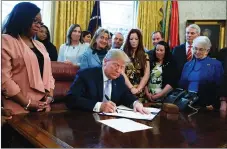  ?? AP PHOTO ?? President Donald Trump signs a new law aimed at curbing sex traffickin­g yesterday in the Oval Office.