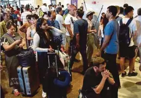  ??  ?? Travellers stranded at the Gusti Ngurah Rai Internatio­nal Airport in Denpasar, Bali.