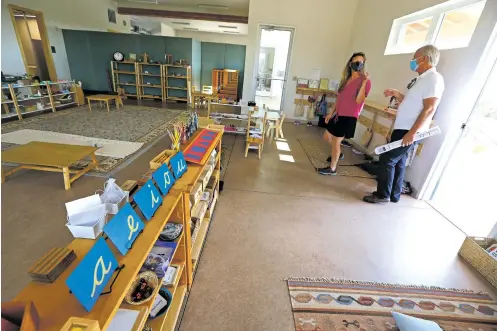  ?? LUIS SÁNCHEZ SATURNO/THE NEW MEXICAN ?? Beth Clayton, head of school at Journey Montessori School, gives Bruce Geiss, chief operating officer of Realty Gift Fund, a tour of the school Thursday.