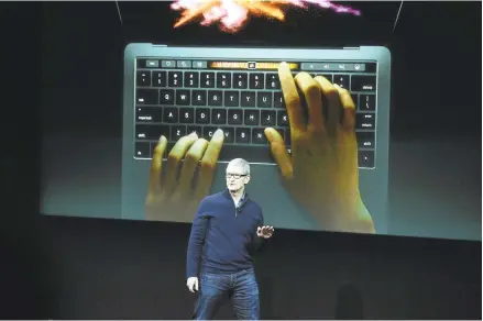  ?? DAN HONDA/STAFF PHOTOS ?? Apple CEO Tim Cook introduces the updated MacBook Pro at company headquarte­rs Thursday in Cupertino. The entry level model will cost $1,500; models with an innovative touch-sensitive display whose screen varies with the functions being carried out by a...