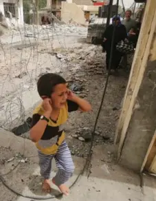  ?? AHMAD AL-RUBAYE/AFP/GETTY IMAGES ?? An Iraqi boy from western Mosul flees his home on Thursday. The UN estimates 350,000 people remain trapped in Daesh-held parts of Mosul.