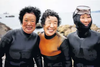  ?? REUTERS ?? Senior haenyeo, also known as “sea women,” Jung Sun-ja, 84, Yoon Yeon-ok, 74, and Ko Keum-sun, 69, pose for a photograph after working in the sea in Busan, South Korea, on April 6.