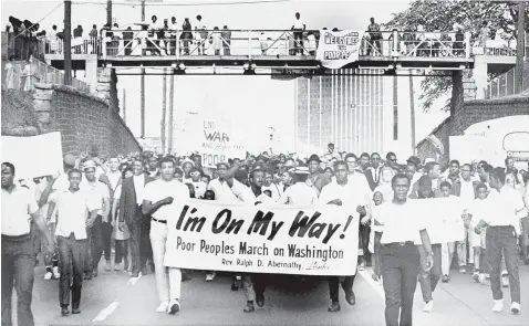  ?? Associated Press ?? ■ In this May 10, 1968, file photo, sign-carrying participan­ts in the southern leg of the Poor People’s Campaign march through Atlanta. Thousands of anti-poverty activists have launched a campaign in May of this year modeled after the Rev. Martin Luther King Jr.’s Poor People’s Campaign of 1968. Like the push 50 years ago, advocates are hoping to draw attention to those struggling with deep poverty from Appalachia to the Mississipp­i Delta, from the American Southwest to California’s farm country.