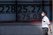  ??  ?? A man passes an electronic stock board outside a securities firm in Tokyo showing Japan’s Nikkei 225 index Wednesday. Shares were mostly lower in Asia on Wednesday. (AP/Eugene Hoshiko)