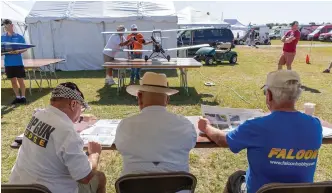  ??  ?? A team of qualified—and critical!—judges scrutinize every detail of the Static Scale entries. Jack Buckley’s beautiful DH Tiger Moth is on the table.