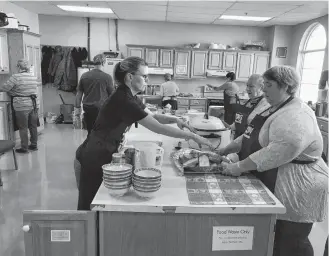  ??  ?? Preparing lunch in the kitchen at Yarmouth Wesleyan Church, one of the venues for Yarmouth’s 100 Meals program, which has concluded for another year. ERIC BOURQUE