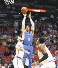  ?? Wilfredo Lee / Associated Press ?? Russell Westbrook, shooting over two Miami defenders, had a triple-double as the Thunder clinched a playoff spot.