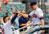  ?? DANIEL SHIREY / GETTY IMAGES ?? Sean Newcomb (right) is greeted by first base coach Eddie Perez after exiting a June 10 game vs. the Mets.