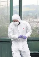  ??  ?? > A forensics officer at the bus stop after the girl was found