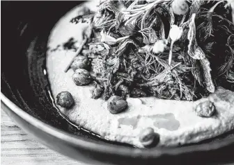  ?? Photos by Kirsten Gilliam ?? Traveler’s Table offers braised lamb shank on garlic hummus with crispy chickpeas, herb salad and grilled flatbread.