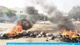  ??  ?? KHARTOUM: Tires are set ablaze by Sudanese protesters during a rally in the capital Khartoum. -—AFP