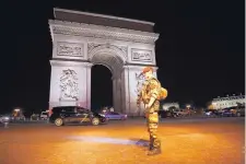  ?? KAMIL ZIHNIOGLU/ASSOCIATED PRESS ?? A soldier stands guard near the Arc de Triomphe at the top of the Champs Élysées avenue in Paris after a fatal shooting in which a police officer was killed along with an attacker on Thursday.