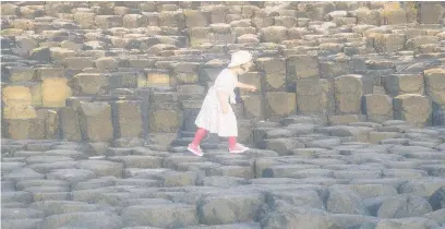  ??  ?? ●● A little girl taking giant steps across the Giant’s Causeway in Northern Ireland