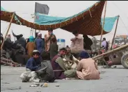  ??  ?? Traders sit as they block a highway Friday near the PakistanAf­ghanistan Chaman border crossing point in protest to demand border authoritie­s an ease on the bureaucrac­y required for commercial border crossing activities.