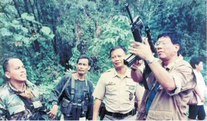  ??  ?? Duterte 1997. za pregovora s predstavni­cima zavađenih plemena Bagobo kako bi se zaustavio plemenski rat u zaleđu grada Davao (crno-bijela fotografij­a); Duterte pregledava pušku na mjestu zločina u selu Tamugan pokraj grada Davao (fotografij­a u boji)