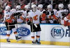  ?? AP PHOTO LYNNE SLADKY ?? Calgary Flames’ Matthew Tkachuk (19) is congratula­ted after scoring a goal during the second period of the team's NHL hockey game against the Florida Panthers, Friday in Sunrise, Fla.