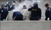  ?? ARIC CRABB — BAY AREA NEWS GROUP ?? Police officers use cutting tools to remove protesters after they shut down traffic along northbound Interstate 880 near the 5th Avenue exit on Monday in Oakland.