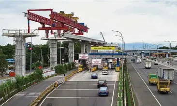  ?? — AFP ?? Optimistic outlook: A file picture shows traffic flowing down a motorway past continuing constructi­on of Jakarta’s new light rail transit system. GDP rose 5.19% in Q4 from a year earlier.