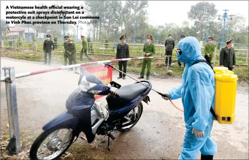  ?? Photo:AFP ?? A Vietnamese health official wearing a protective suit sprays disinfecta­nt on a motorcyle at a checkpoint in Son Loi commune in Vinh Phuc province on Thursday.