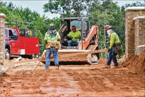  ?? PHOTOS BY HYOSUB SHIN / HYOSUB.SHIN@AJC.COM ?? Crews work last month on an Alpha Loop section at Atley, a new subdivisio­n in Alpharetta. The city’s current fiscal year 2021 budget showed $9 million of the project unfunded, which includes part of the loop from Old Milton Parkway to Northwinds and from Westside Parkway to Northwinds.