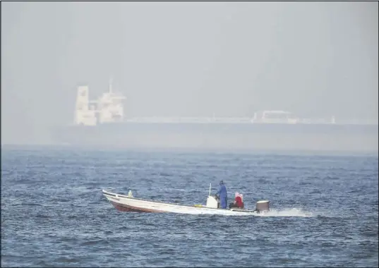  ?? Jon Gambrell The Associated Press ?? A fishing boat speeds past an oil tanker Saturday in Fujairah, United Arab Emirates. The Kokuka Courageous, one of two oil tankers targeted in an apparent attack in the Gulf of Oman, was brought to the United Arab Emirates’ eastern coast Saturday.