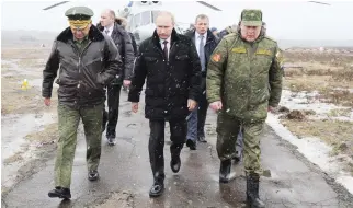  ??  ?? Putin walks to watch military exercises upon his arrival at the Kirillovsk­y firing ground. (file/Reuters)