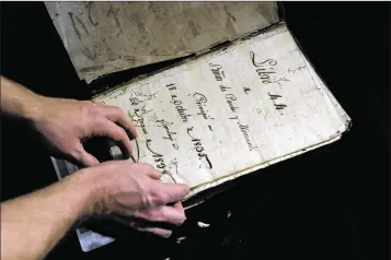  ?? RAMON ESPINOSA / ASSOCIATED PRESS ?? U.S. history professor David Lafevor holds a colonial-era registry at the Santo Espirito Church in Old Havana. His team is digitizing many of the meticulous­ly kept records that document Cuba’s colonial era.