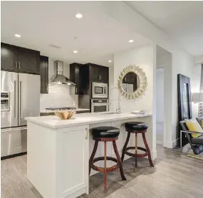  ?? PHOTOS: DAVINCI HOMES ?? The kitchen, with full-sized appliances and a full-height glass tile backsplash in the E floor plan at Riviera on the Bow, by DaVinci Homes.