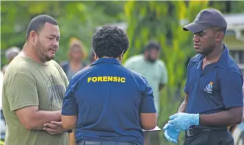 ?? Photo: Ronald Kumar ?? Makrau Sakiasi (left) with Police forensic team after identifyin­g his 48 year-old brother’s body, which was found on roadside at Sarosaro raod in Vatuwaqa on December 28, 2018.