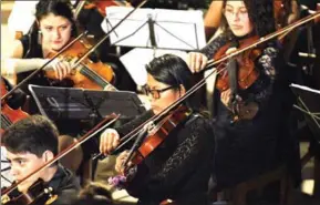  ?? AIZAR RALDES/AFP ?? Bolivian coca grower Mariel Chura (centre), 21, plays the viola during a presentati­on of the Youth Symphonic Orchestra of Chulumani, some 120km north of La Paz, on November 21.