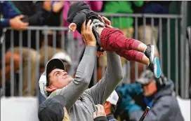  ?? DREW HALLOWELL / GETTY IMAGES ?? Keegan Bradley holds up his son, Logan, after winning the BMW Championsh­ip on Monday at Aronimink Golf Club in Newtown Square, Pennsylvan­ia.