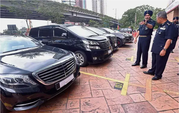  ??  ?? ‘Hot’ wheels: Federal Commercial Crimes Investigat­ion Department (CCID) director Comm Datuk Seri Amar Singh pointing at the eight luxury cars seized from the investment group. — RAJA FAISAL HISHAN/ The Star