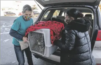  ?? AP PHOTO/JACK RENDULICH ?? Leech Lake Legacy volunteers Cindy Ojczyk (left) and Engress Clark unload a kennel with some of the kittens that were abandoned in Cass Lake, Minn., on Nov. 21.