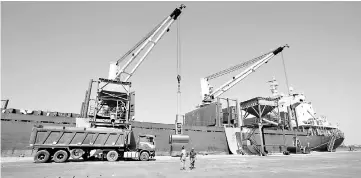  ??  ?? Workers unload aid shipment of wheats from St George ship, at the Red Sea port of Hodeidah, Yemen in this file photo. — Reuters photo