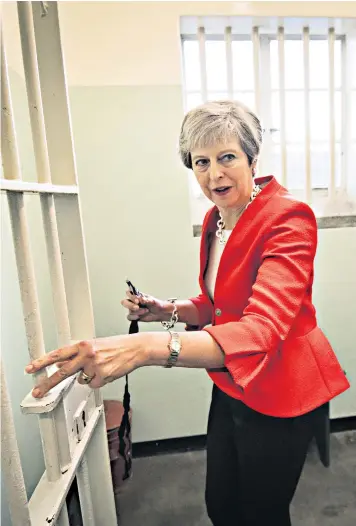  ??  ?? Theresa May steps into the Robben Island prison cell where Nelson Mandela, the former South African president, spent 18 years, from 1964 to 1982. She wrote in the guest book that it had been a ‘privilege’ to visit in the centenary year of Mandela’s birth