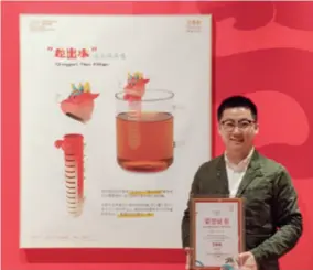  ?? ?? Wang Zijian holds up his award certificat­e next to his work at the Beijing Overseas Cultural Exchange Center on December 21, 2023