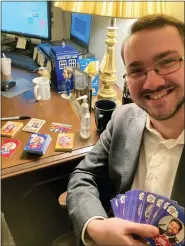  ?? JULIE CARR SMYTH — THE ASSOCIATED PRESS ?? Ohio House legislativ­e aide Adam Headlee sits in his office Dec. 17 at the Riffe Center in Columbus, displaying trading cards he had signed by all 99state representa­tives.