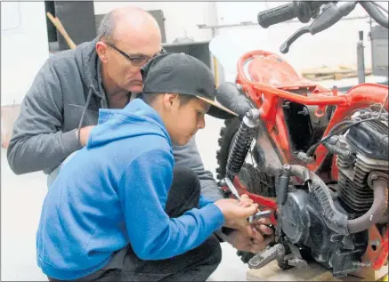  ?? Photo / Bethany Rolston ?? Pathways Centre mentor Frank Berkers and mentee Renata Slade, 11, tinkering with a dirt bike during a mentoring session at Pathways Centre.