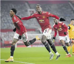  ?? (Photo: AFP) ?? Manchester United’s English striker Marcus Rashford (left) reacts after scoring the opening goal as Manchester United’s French midfielder Paul Pogba (centre) chases him during their English Premier League match against Wolverhamp­ton Wanderers at Old Trafford in Manchester, north-west England, on Tuesday.