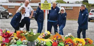  ??  ?? Tributes: Football club members at the spot where Jordan was struck