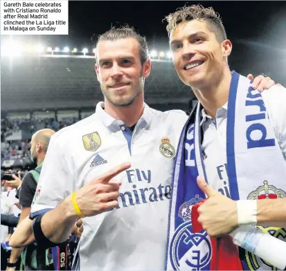  ??  ?? Gareth Bale celebrates with Cristiano Ronaldo after Real Madrid clinched the La Liga title in Malaga on Sunday