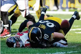  ?? JOE SARGENT / GETTY IMAGES ?? The Falcons’ Matt Ryan fumbles the ball as he is hit by T.J. Watt of the Pittsburgh Steelers in the fourth quarter at Heinz Field on Sunday in Pittsburgh. Ryan was sacked six times and hit 11 times in the 41-17 loss.