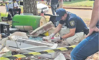  ?? ?? El comisario Luis Pizzani, de Seguridad Bancaria, revisa los billetes entintados que quedaron.