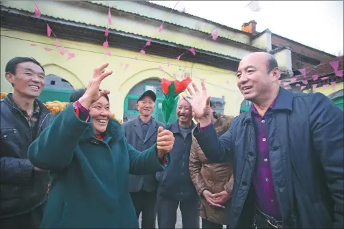  ?? PHOTOS BY SUN RUISHENG / CHINA DAILY ?? Wang Zhuhong (left) looks on as a fellow villager performs a magic trick in Liyu village in Wuxiang county, Shanxi province.