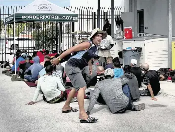  ?? CARL JUSTE cjuste@miamiheral­d.com ?? Cuban migrants wait to be processed on Wednesday. About 40 men, women and some small children were processed by the Border Patrol at the agency’s station in the Middle Florida Keys city of Marathon.