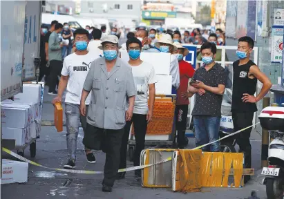  ?? (Thomas Peter/Reuters) ?? PEOPLE WALK INSIDE the now-closed Jingshen seafood market in Beijing last week.