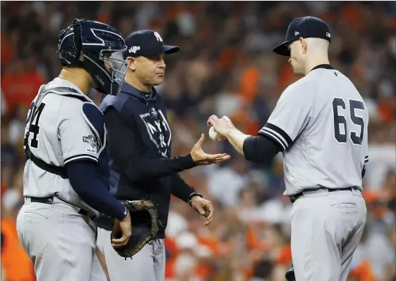  ?? MATT SLOCUM — THE ASSOCIATED PRESS ?? Yankees starting pitcher James Paxton right, is taken out of the game by manager Aaron Boone during the third inning in Game 2. Boone loves a stroll to the mound and his management, or mismanagem­ent, of the bullpen could determine the series.