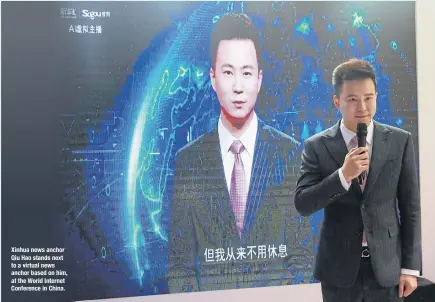  ??  ?? Xinhua news anchor Qiu Hao stands next to a virtual news anchor based on him, at the World Internet Conference in China.